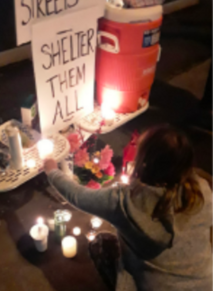 A vigil, featuring a sign reading &ldquo;Shelter them All&rdquo;